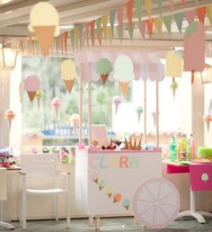 an ice cream cart is decorated with bunting and paper garlands in pastel colors