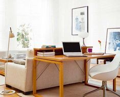 a living room filled with furniture and a laptop computer on top of a wooden table