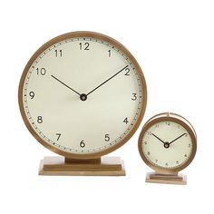 two clocks sitting side by side on top of each other in front of a white background