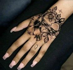 a woman's hand with flowers on it and a cross in the middle,