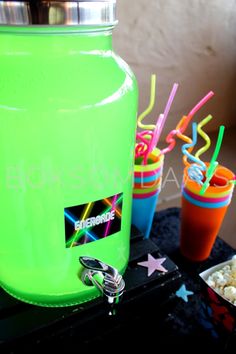 a neon green beverage dispenser sitting on top of a table next to drinks