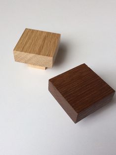 two pieces of wood sitting next to each other on a white surface with one piece missing