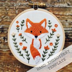 an embroidered fox with flowers and leaves on it's face is shown in the hoop