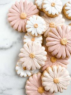 cookies decorated with pink and white flowers on a marble surface