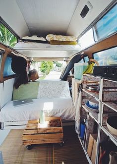 the interior of a camper van with bed, shelves and drawers on each side