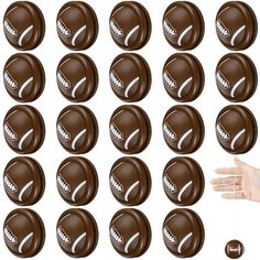 a hand is reaching for chocolate balls with white letters on them, set against a white background