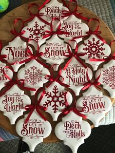 some cookies that are on top of a wooden board with red ribbon around them and the words, merry christmas and celebrations