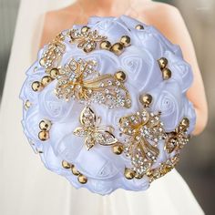 the bride's bouquet is made up of flowers and gold brooches,