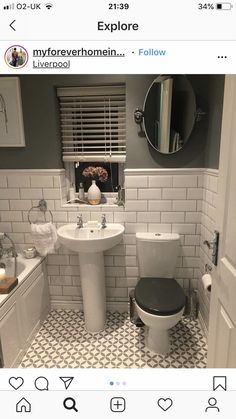 the bathroom is decorated in gray and white tile, with black accents on the walls