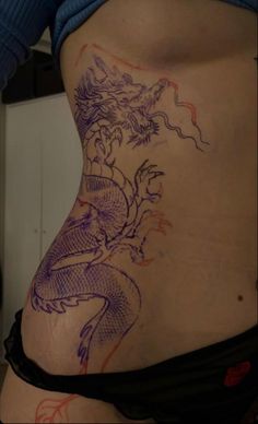 a woman with a dragon tattoo on her stomach