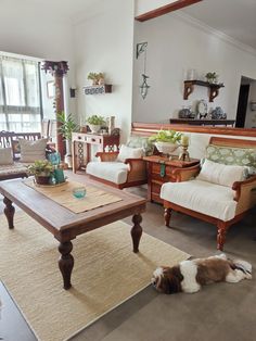 a living room filled with furniture and a dog laying on the floor next to it