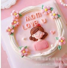 there is a cake that says mom love u on the top and flowers around it