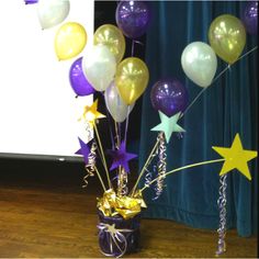 some balloons and streamers in a purple vase