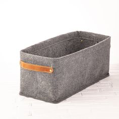 a gray felt storage bin with leather handles