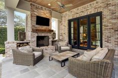 an outdoor living area with wicker furniture and fireplace