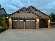 a house with two garage doors and lights on