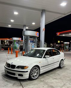 a white car parked in front of a gas station