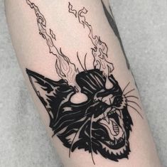 a black and white cat tattoo on the leg