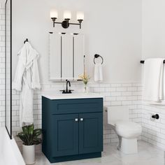 a bathroom with white tile and blue cabinets