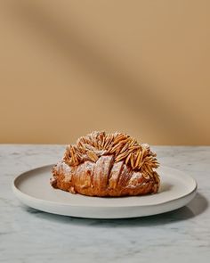 a white plate topped with a pastry covered in powdered sugar