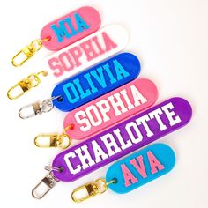 four name key chains with different colors on them