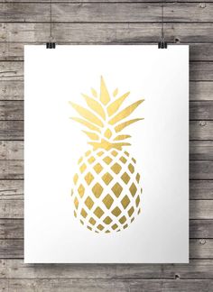 a white and gold pineapple poster on a wooden wall next to a wood floor