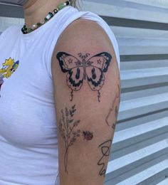 a woman with a butterfly tattoo on her arm