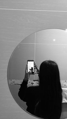 a woman is taking a selfie in front of a mirror with her cell phone