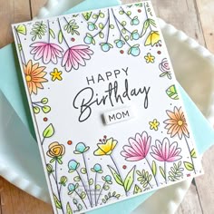 a birthday card with flowers on it and the words happy birthday mom written in black ink