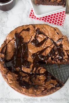 there is a chocolate cake on the table with one slice cut out and ready to be eaten