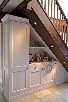 an under the stairs storage area with built in bookshelves and cabinets underneath it