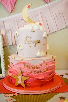 a pink and white cake sitting on top of a table