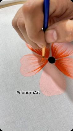 someone is doing something with their hand and using a pencil to draw an orange flower