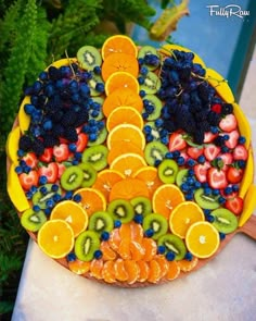 a platter filled with lots of fruit on top of a table