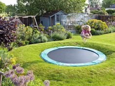 a backyard with a trampoline and some kids playing in the yard, and an above ground trampoline pool