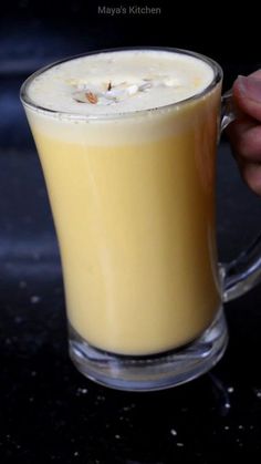 a person holding a glass mug filled with liquid