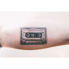 a man's arm with an old school cassette tattoo on it