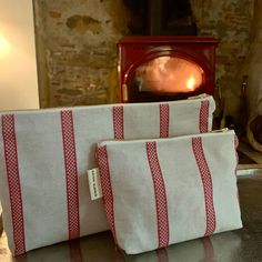 two red and white bags sitting on top of a table next to a fire place