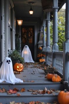 halloween decorations on the front steps of a house with ghost heads and pumpkins around them