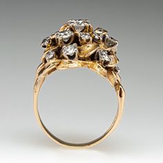 a gold ring with diamonds and leaves on it