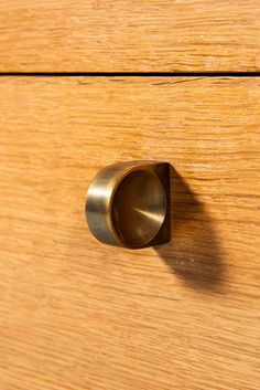 a close up of a wooden drawer with a metal knob on it's side