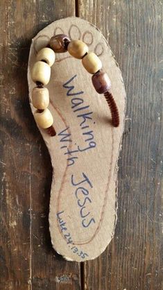 a wooden beaded bracelet hanging on the side of a wood door with words written on it