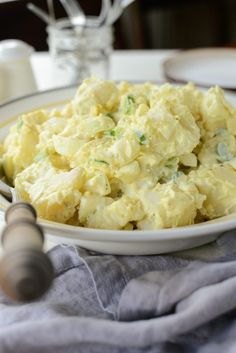 a white plate topped with scrambled eggs on top of a blue table cloth next to a bottle