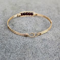 A contemporary little bracelet of five strands of 14kt gold filled wire with a center design featuring five 4mm genuine garnet beads and accented with two smaller beads. Perfect for that January birthday girl! Stackable, too, along with many of my other wirewrapped bracelets! The sturdy built-in hook and eye clasp is easy to get on and off by yourself. Choose the size you need for a comfortable custom fit. Adjustable Hand-strung 14k Gold Filled Bracelet, Gold Hand-wrapped Bracelet, Everyday Hand Wrapped Bangle Bracelet, Gold Wire Wrapped Brass Bracelets, Wire Wrapped 14k Gold Filled Bracelets, Gold Wire Wrapped 14k Gold-filled Bracelets, Gold Wire Wrapped Bracelets In 14k Gold Filled, Gold Brass Wire Wrapped Bracelets, Adjustable 14k Gold-filled Jubilee Bracelet