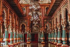 an ornately decorated room with chandelier and columns