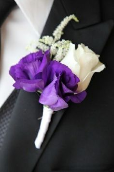 a boutonniere with purple and white flowers on it's lapel