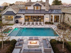 an aerial view of a house with a pool and fire pit in the middle of it