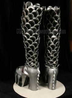 a pair of silver shoes sitting on top of a white plate next to a black background