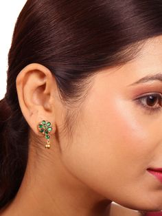 This Malti stud earring is fashioned from 925 silver and tastefully polished with a hint of gold. This Malti stud showcases an intricate flower design, while the classic earrings adorned with the resplendent beauty of green emerald and delicate ball dangles. This combination enriches the earring appearance, making it a symbol of timeless elegance. Please refer to the pictures of the jewelry worn on a model to get a clear idea of the size. Condition: New. This product is intricately designed and meticulously handcrafted with exceptional care by our skilled silversmiths, employing traditional Indian techniques. Every jewelry piece from Sashastrends bears a 925-hallmark stamp! Earring closure: Screw back. Material: 925 silver (gold polish), green emerald. Place of Origin: Bangalore, India. Green Sterling Silver Flower-shaped Earrings, Classic Single Green Earring, Classic Green Single Earring, Elegant Green Flower Earrings For Formal Occasions, Elegant Green Round Flower Earrings, Elegant Green Plug Earrings As Gift, Elegant Green Plug Earrings For Gift, Traditional Green Flower Earrings, Flower Shaped Earrings For Celebration