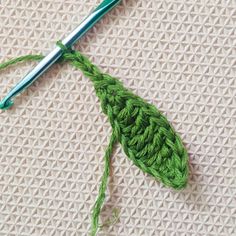 a crochet hook with green yarn on it